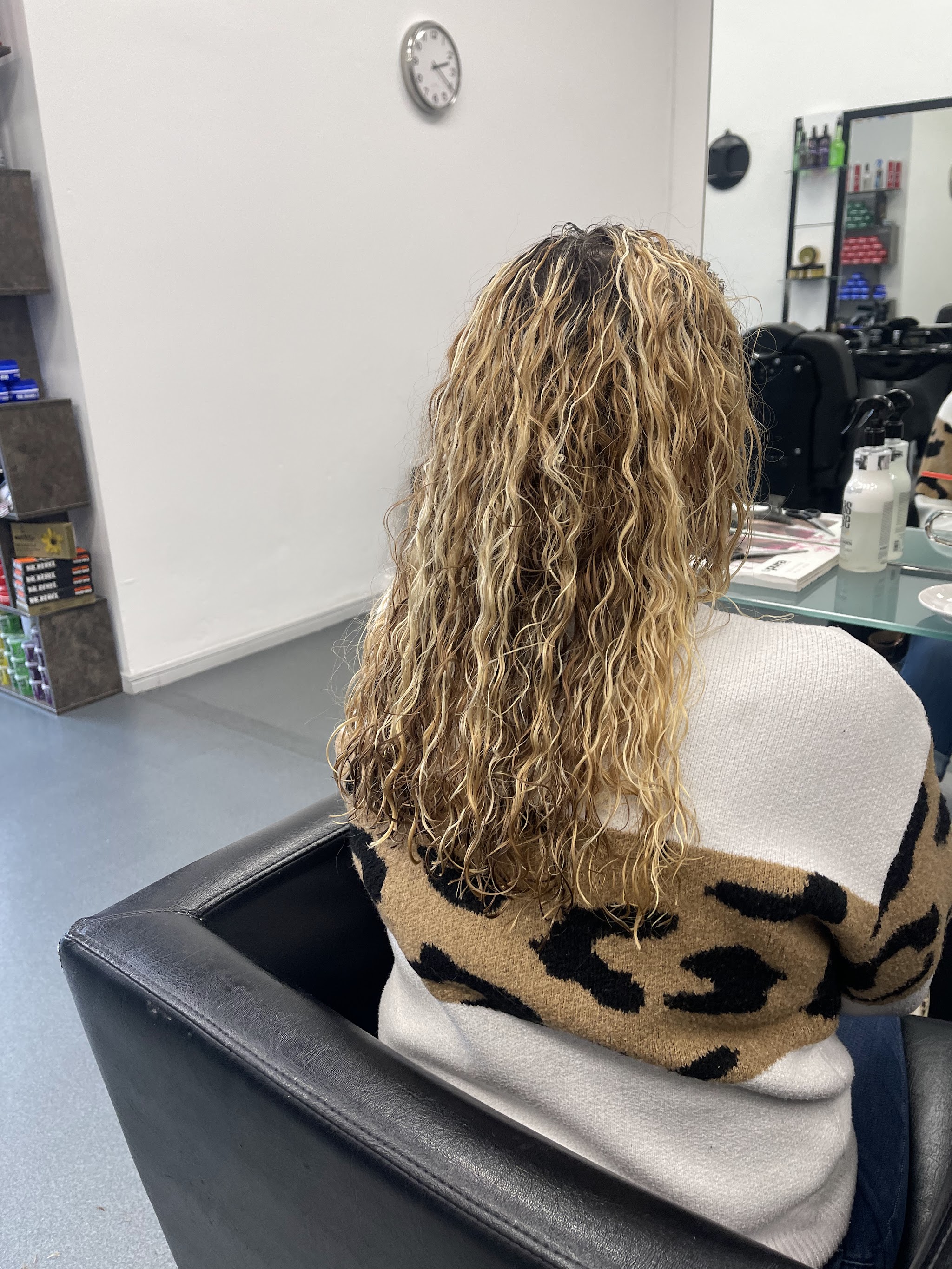 Lang blond krullend haar van achteren, in de stoel bij Soul Hairshow