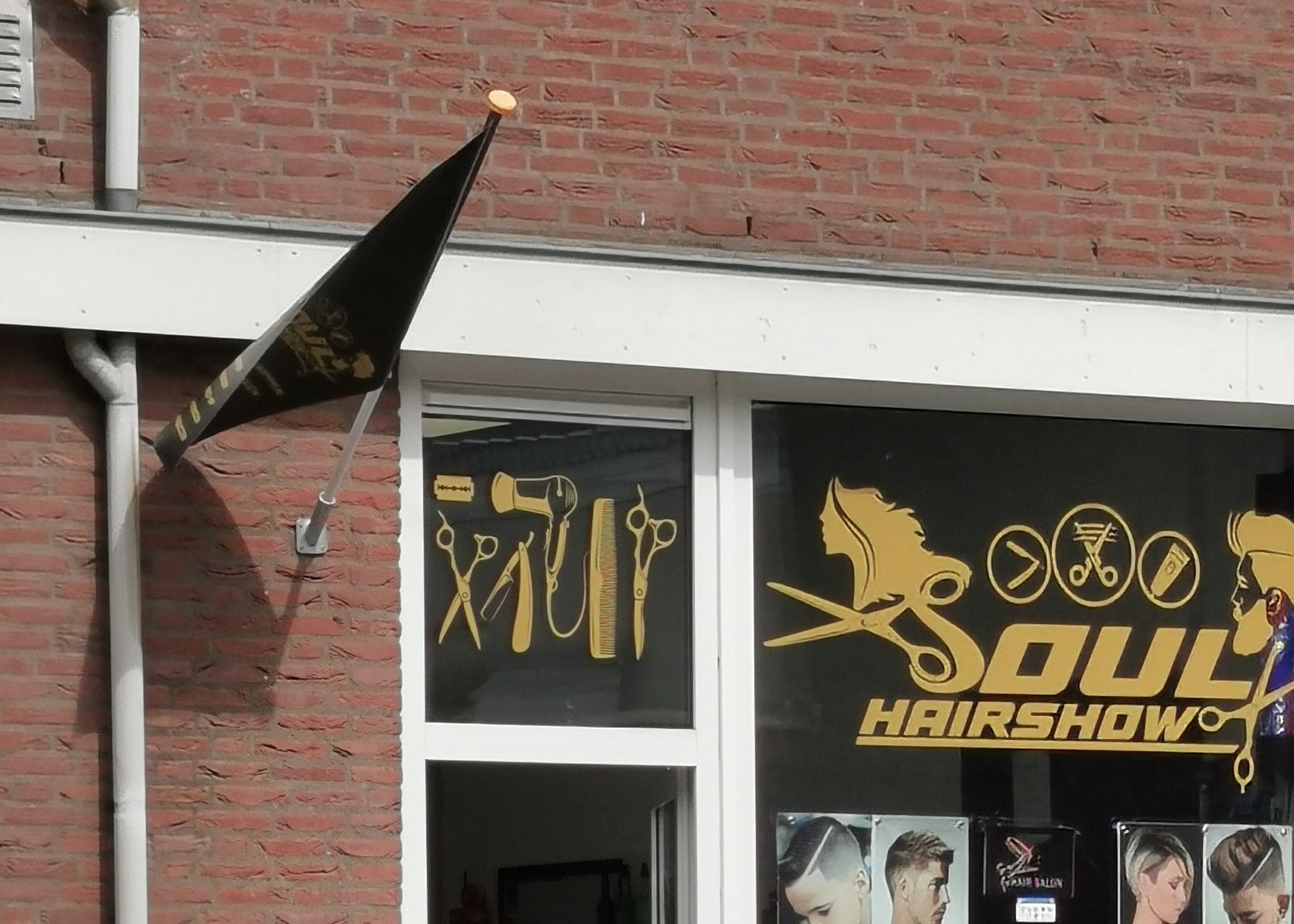 De gevel van Soul Hairshow aan de Lokerstraat: rode baksteen, witte kozijnen en het gouden logo op het raam